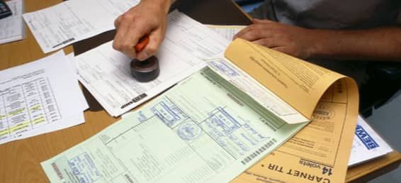 Freight forwarder calculating shipping costs and reviewing customs documents in China