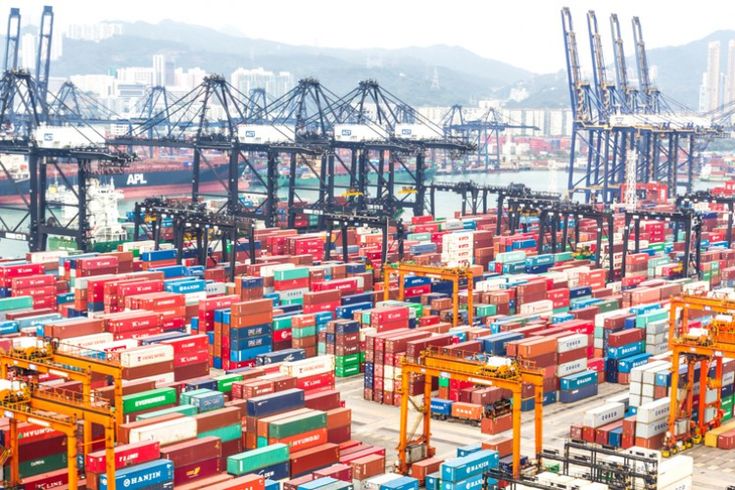 Busy Chinese container port with stacked colorful containers and cranes.